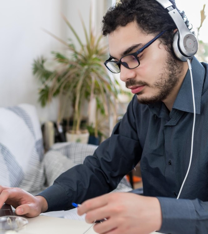 Diversity and Inclusion New Zealand - flexible learning options background Flexible learning options: Person wearing headphones and focusing on a laptop screen